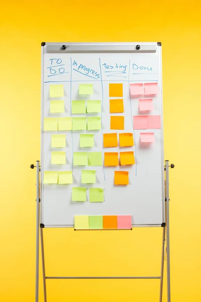 Tableau de bureau blanc avec des notes collantes et l'espace de copie isolé sur jaune — Photo de stock