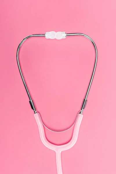 Vue du dessus du stéthoscope médical sur fond rose, concept de cancer du sein — Photo de stock