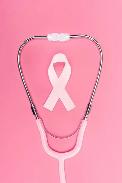 Vista superior do sinal de câncer de mama rosa no estetoscópio no fundo rosa — Fotografia de Stock