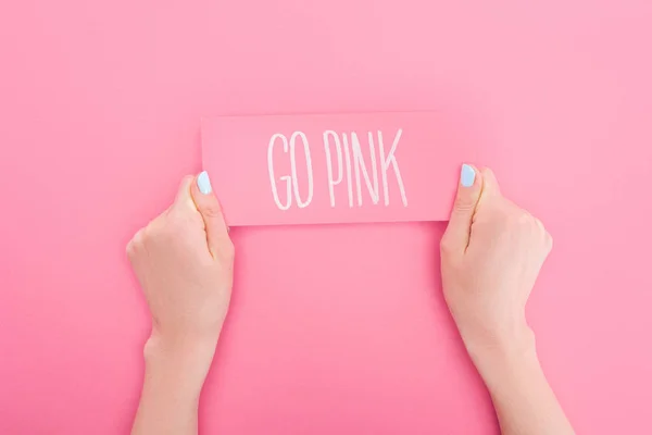 Partial view of woman holding pink card with go pink lettering on pink background — Stock Photo