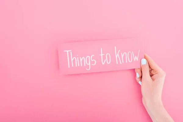 Partial view of woman holding card with things to know lettering on pink background — Stock Photo