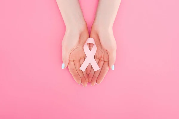 Vista parcial de la mujer con signo de cáncer de mama rosa sobre fondo rosa - foto de stock