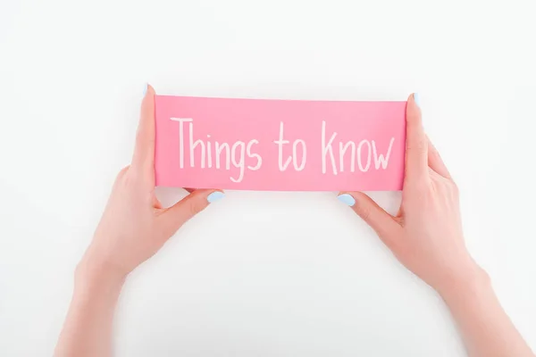 Cropped view of woman holding pink card with things to know lettering on white background — Stock Photo