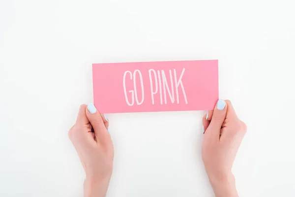 Vista parcial de la mujer sosteniendo tarjeta rosa con letras de color rosa sobre fondo blanco - foto de stock