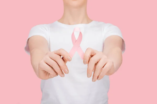 Partial view of woman in white t-shirt holding pink breast cancer sign isolated on pink — Stock Photo