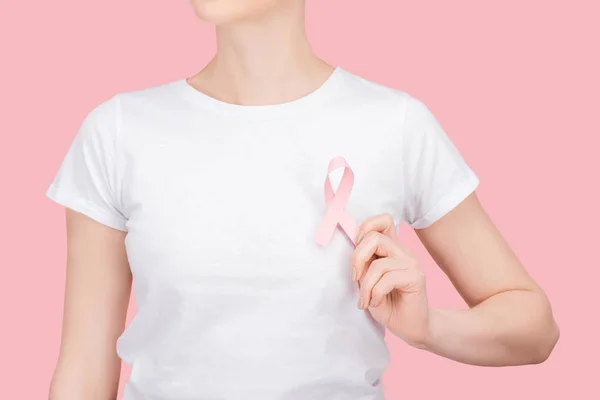 Partial view of woman in white t-shirt with pink breast cancer sign isolated on pink — Stock Photo