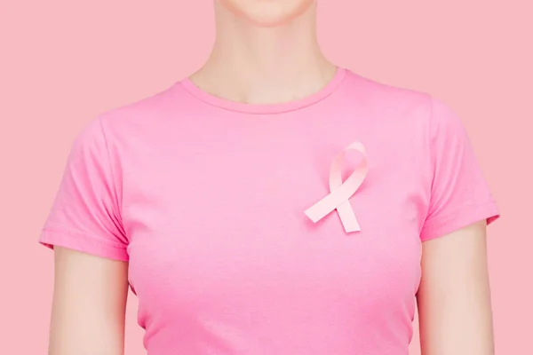 Recortado vista de la mujer en rosa camiseta con cáncer de mama de seda cantar aislado en rosa - foto de stock