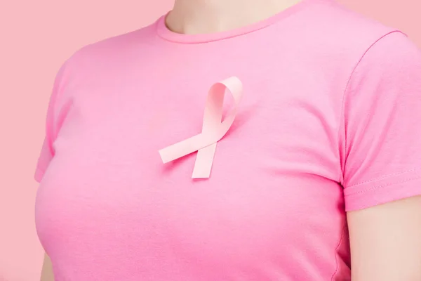 Close up view of woman in pink t-shirt with breast cancer sing isolated on pink — Stock Photo