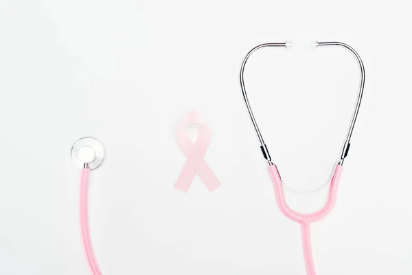 Vista superior del estetoscopio y el signo de cáncer de mama rosa sobre fondo rosa - foto de stock