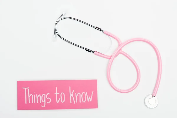 Top view of stethoscope and pink card with things to know lettering on white background — Stock Photo