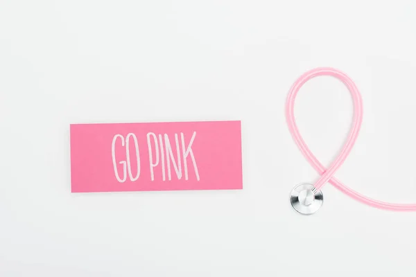 Vista dall'alto dello stetoscopio e carta con scritte rosa go su sfondo bianco — Foto stock