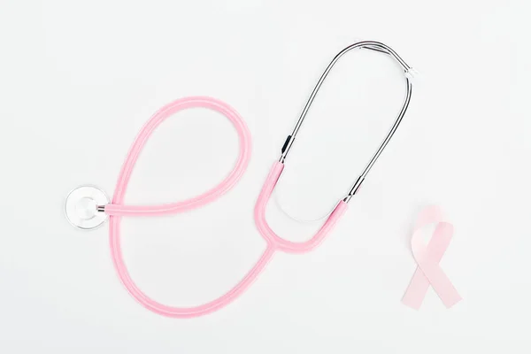 Top view of stethoscope and pink breast cancer bow on white background — Stock Photo