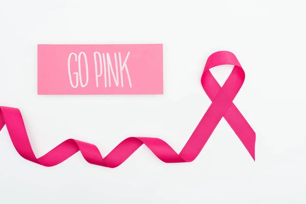 Top view of curved crimson breast cancer ribbon and card with go pink lettering on white background — Stock Photo