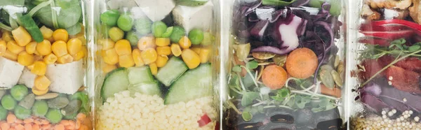 Vue rapprochée de la salade de légumes frais dans des bocaux en verre sur table blanche en bois isolé sur blanc — Photo de stock