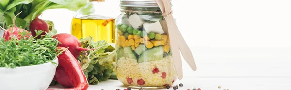 Свіжий овочевий салат у скляній банці з дерев'яними столовими приборами ізольовані на білому, панорамний знімок — стокове фото