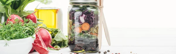 Ensalada de verduras frescas en frasco de vidrio cerca de especias y rábano aislado en blanco, plano panorámico - foto de stock