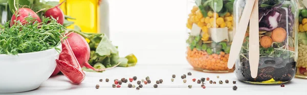 Ensalada de verduras frescas en frascos de vidrio con cubiertos de madera aislados en blanco, plano panorámico - foto de stock