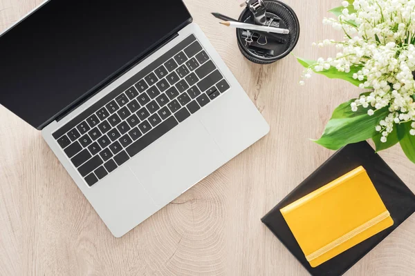 Vista dall'alto di cancelleria, laptop e blocco appunti su tavolo in legno — Foto stock