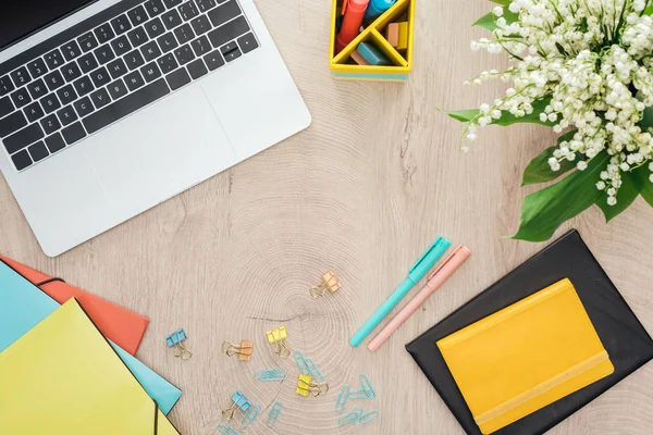 Draufsicht auf Laptop, Schreibwaren, Notizblöcke und Stifte auf Holztisch — Stockfoto