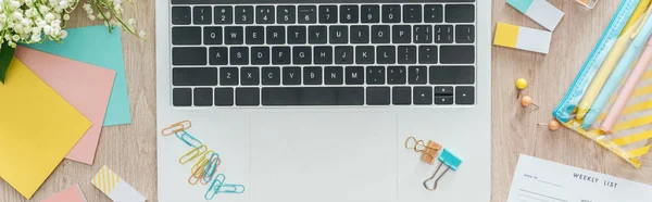 Vista panorámica del teclado portátil con papelería en la mesa de madera - foto de stock