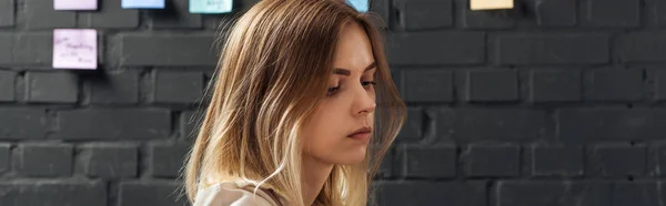 Woman looking away, standing near brick wall with colorful sticker pads — Stock Photo