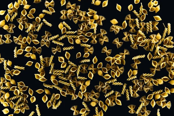 Top view of mixed uncooked pasta isolated on black — Stock Photo