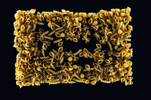 Draufsicht auf ungekochte Pasta in Rechteckform isoliert auf schwarz — Stockfoto