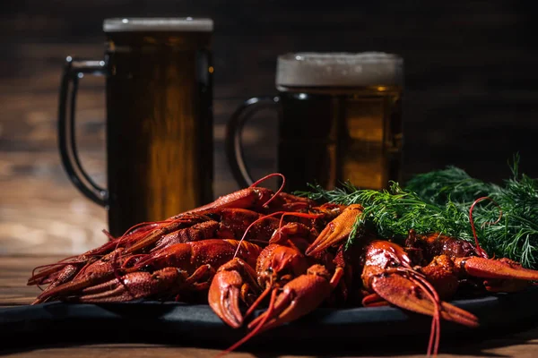 Lagostas vermelhas, endro e copos com cerveja na superfície de madeira — Fotografia de Stock