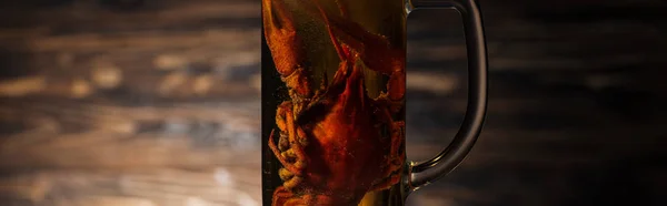 Panoramic shot of red lobsters in glass with beer on wooden surface — Stock Photo