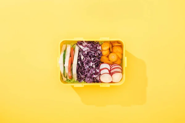 Vista superior da lancheira com sanduíches e legumes no fundo amarelo — Fotografia de Stock