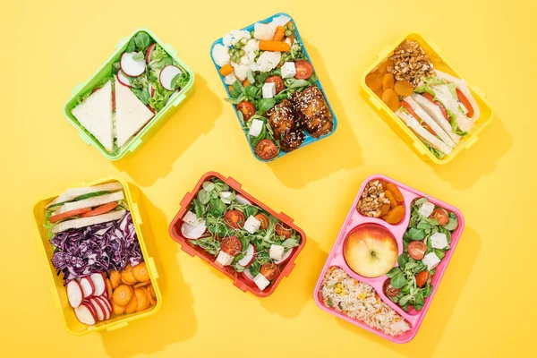 Вид зверху на обідні коробки зі свіжою їжею на жовтому фоні — стокове фото