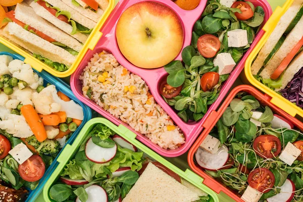 Vista de cerca de coloridas loncheras con comida - foto de stock