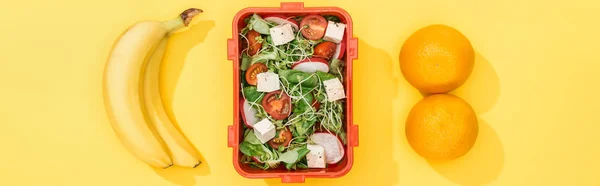 Panoramaaufnahme einer Lunchbox mit Lebensmitteln in der Nähe von Bananen und Orangen — Stockfoto