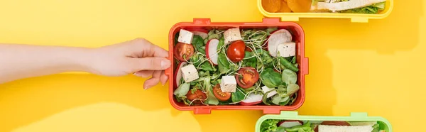 Vue recadrée de femme choisissant boîte à lunch avec de la nourriture — Photo de stock