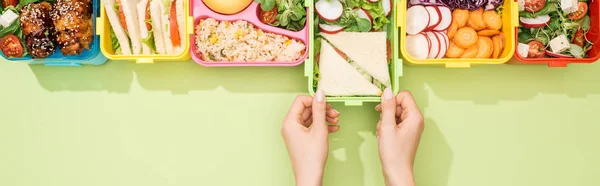 Cropped view of woman choosing lunch boxes with food — Stock Photo