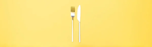 Панорамний знімок виделки і ножа на жовтому — стокове фото