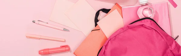 Panoramic shot of backpack with folders, stationery and bottle of water — Stock Photo