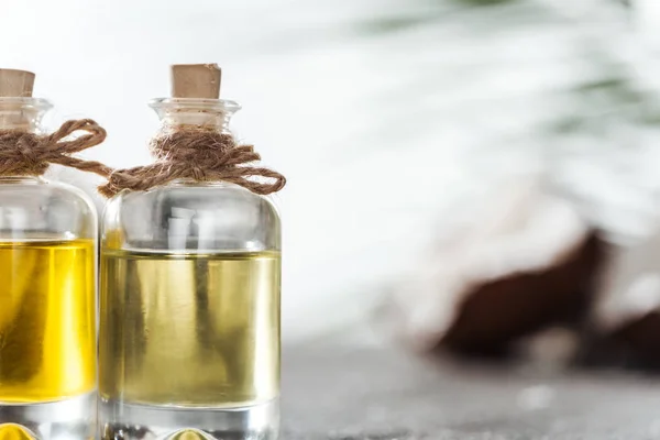 Close up view of bottles with yellow coconut oil and corks — Stock Photo