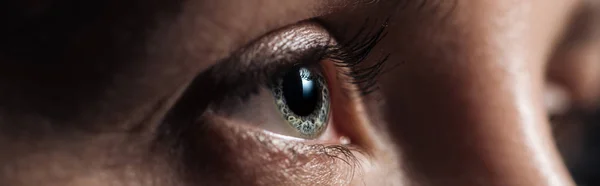 Close up view of human eye looking away in dark, panoramic shot — Stock Photo