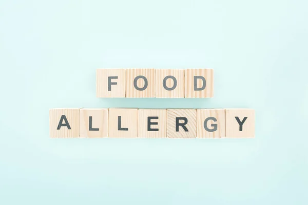 Vista superior de blocos de madeira com palavras alergia alimentar em azul — Fotografia de Stock