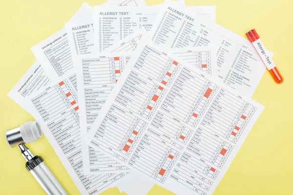 Top view of allergy test results near test tube and dermatoscope isolated on yellow — Stock Photo