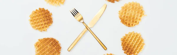 Panoramic shot of waffles with fork and knife in middle isolated on white — Stock Photo