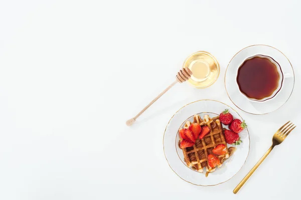 Vue de dessus du délicieux petit déjeuner avec gaufres, fraises et thé sur blanc — Photo de stock