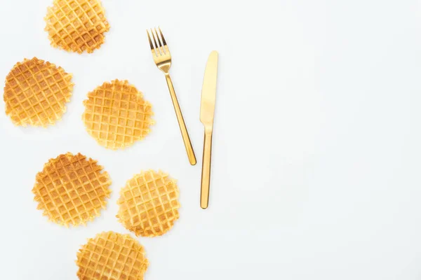 Top view of golden cutlery near waffles isolated on white — Stock Photo