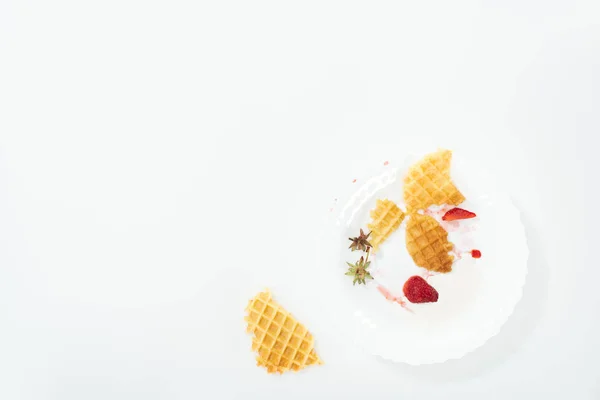 Top view of eaten waffles and strawberries on plate on white — Stock Photo