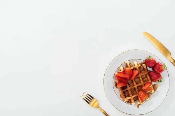 Vista superior da placa com waffles perto do garfo e da faca no branco — Fotografia de Stock