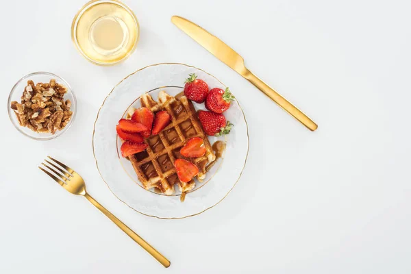 Flat lay with waffles and strawberries on plate near bowls on white — Stock Photo