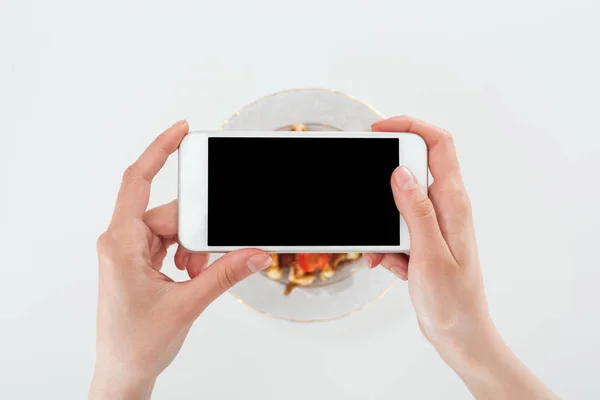 Vista cortada da mulher tirando foto da placa com waffle e morangos isolados no branco — Fotografia de Stock
