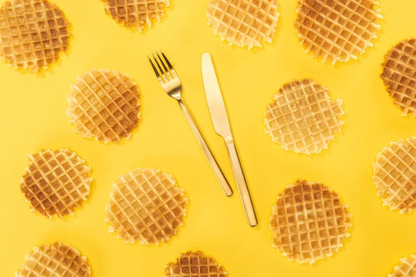 Vista superior de waffles com talheres no meio isolado em amarelo — Fotografia de Stock
