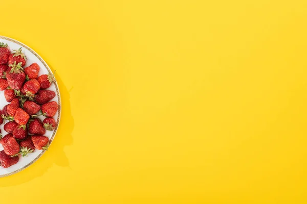 Vue de dessus de la plaque avec des fraises sur jaune — Photo de stock